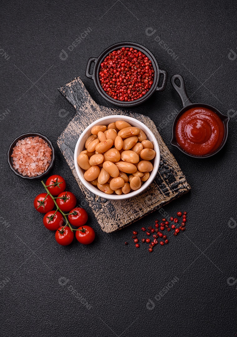 Delicioso feijão enlatado nutritivo com tomate, com sal e temperos como complemento de alto teor calórico para o café da manhã