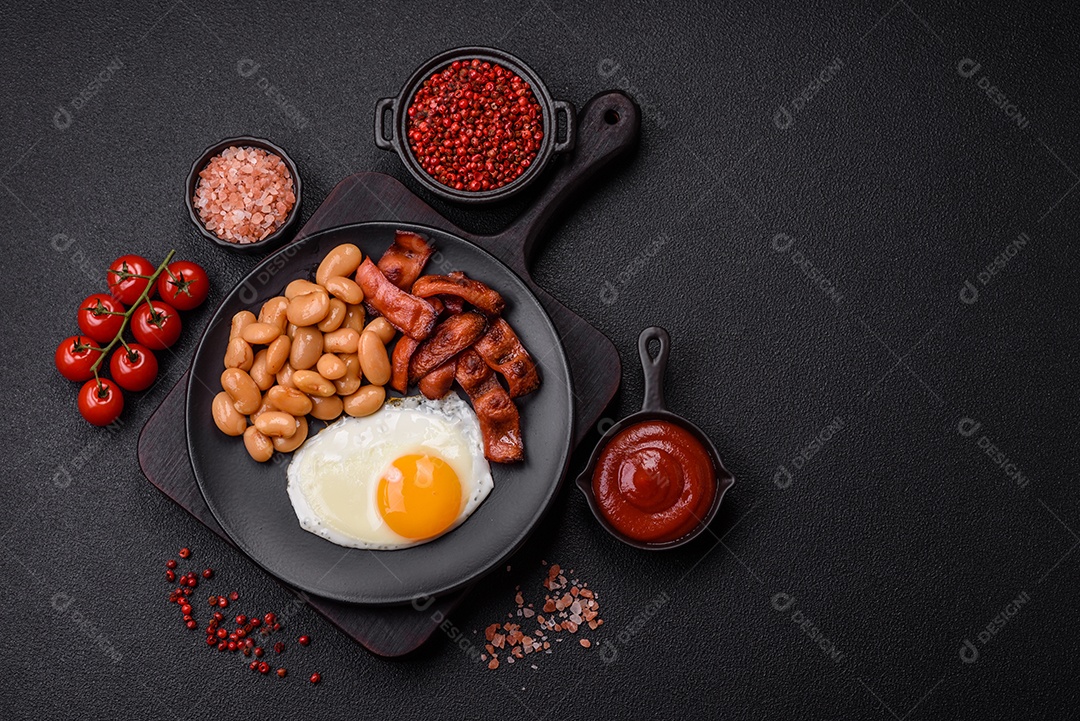 Café da manhã inglês com ovos fritos, bacon, feijão, tomate, especiarias e ervas. Um início de dia saudável e nutritivo