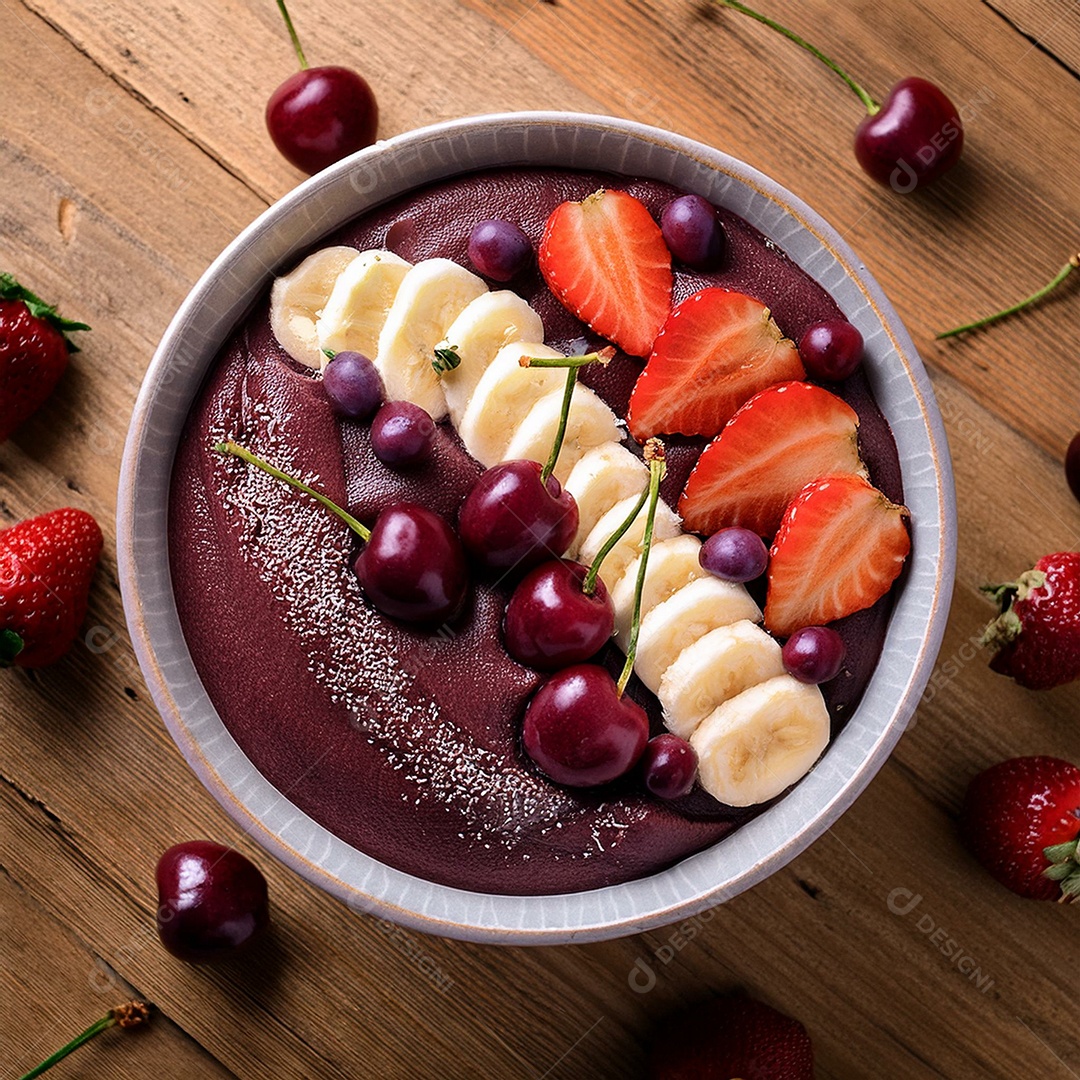 Vista superior de uma tigela cheia de açaí cremoso com cerejas e morangos por cima