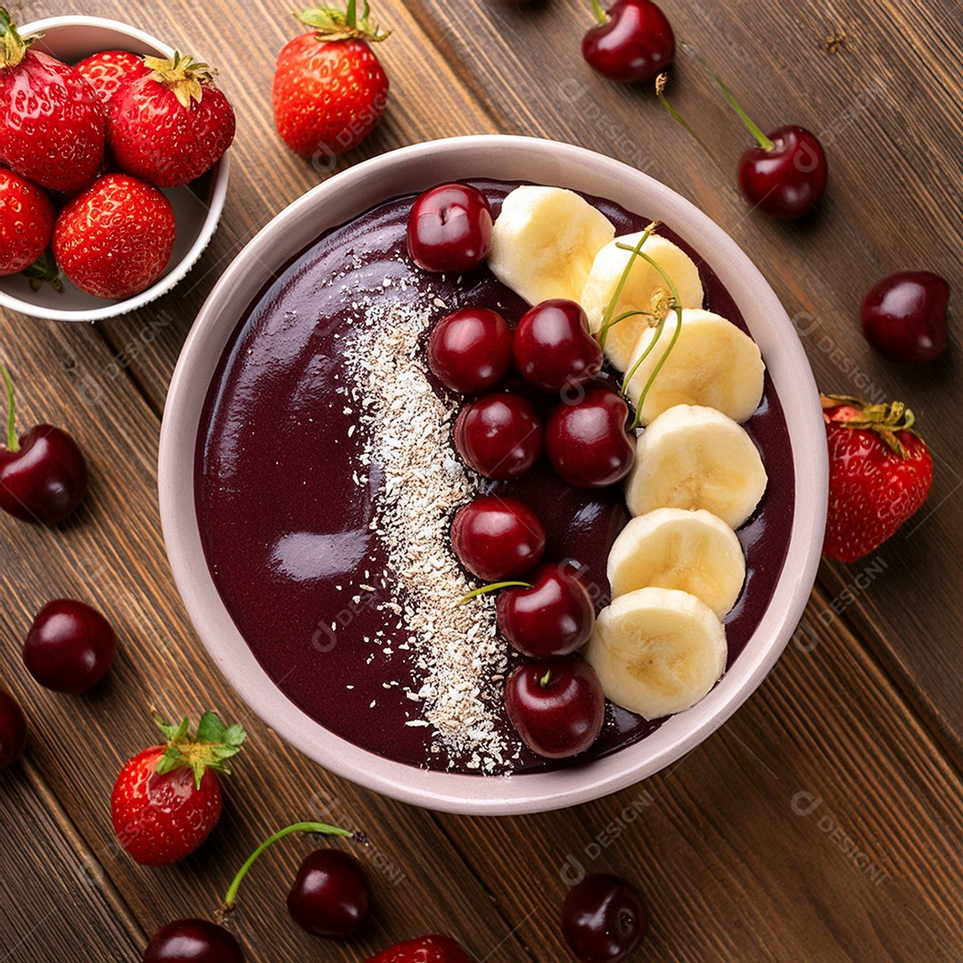 Vista superior de uma tigela cheia de açaí cremoso com cerejas e morangos por cima