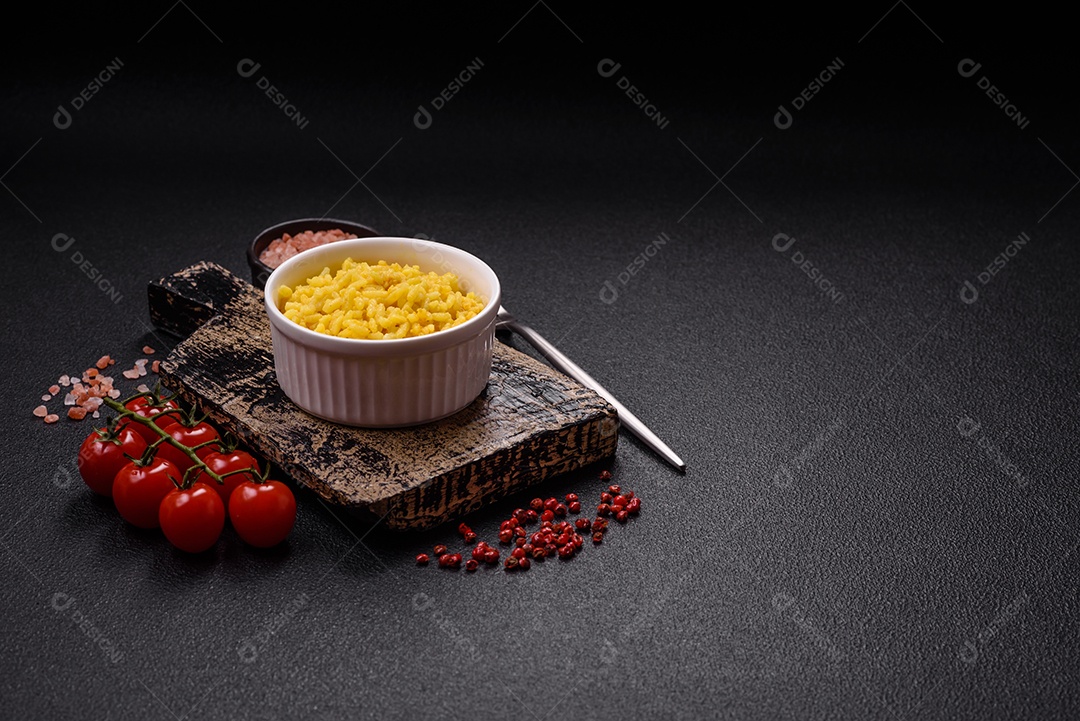 Delicioso arroz amarelo cozido com açafrão, sal e especiarias sobre um fundo escuro de concreto