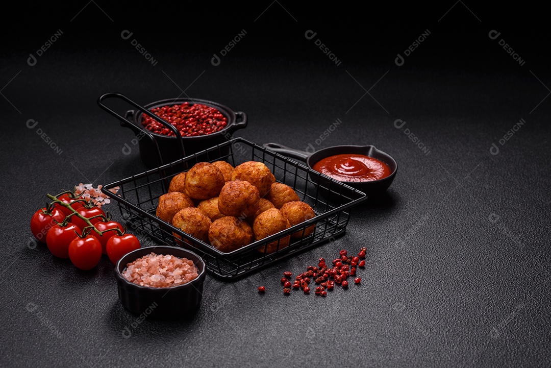 Deliciosas bolas crocantes empanadas com queijo mussarela, sal e especiarias em fundo escuro de concreto