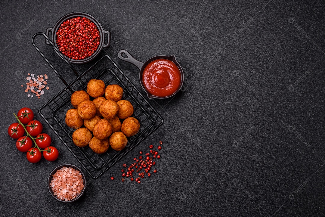 Deliciosas bolas crocantes empanadas com queijo mussarela, sal e especiarias em fundo escuro de concreto