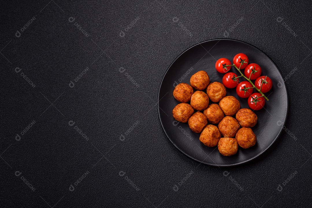 Deliciosas bolas crocantes empanadas com queijo mussarela, sal e especiarias em fundo escuro de concreto
