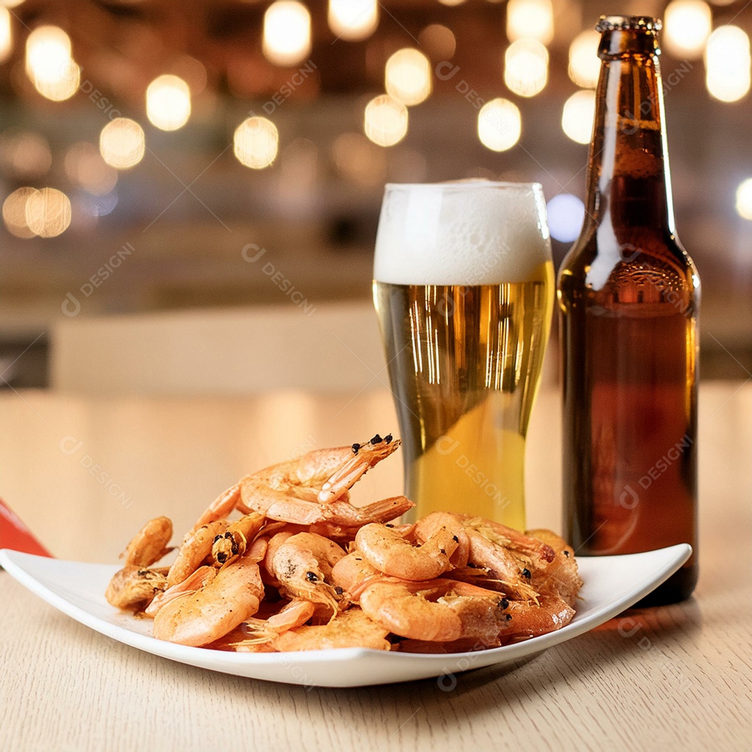 Camarões fritos ao lado de uma garrafa de cerveja