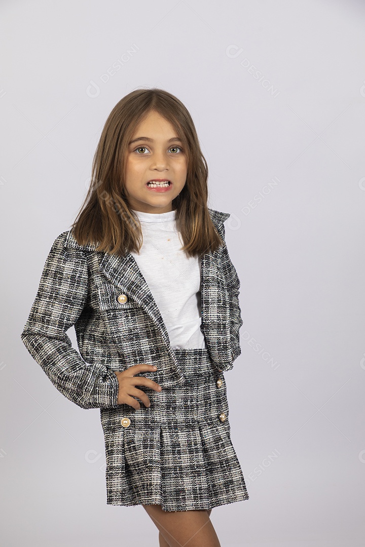 Uma linda garotinha sorrindo com mãos na cintura