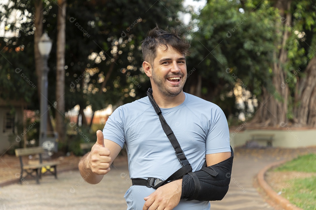 Homem sorrindo com tipoia no braço