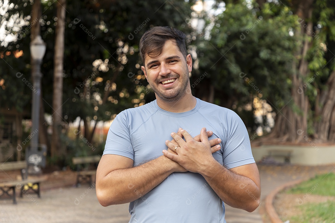Homem sorrindo com mãos no peito