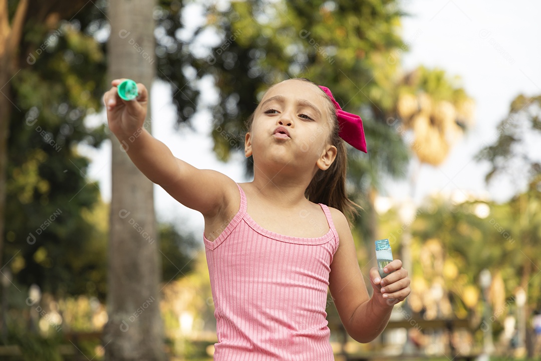 Menina linda brincando com bolhas de sabão