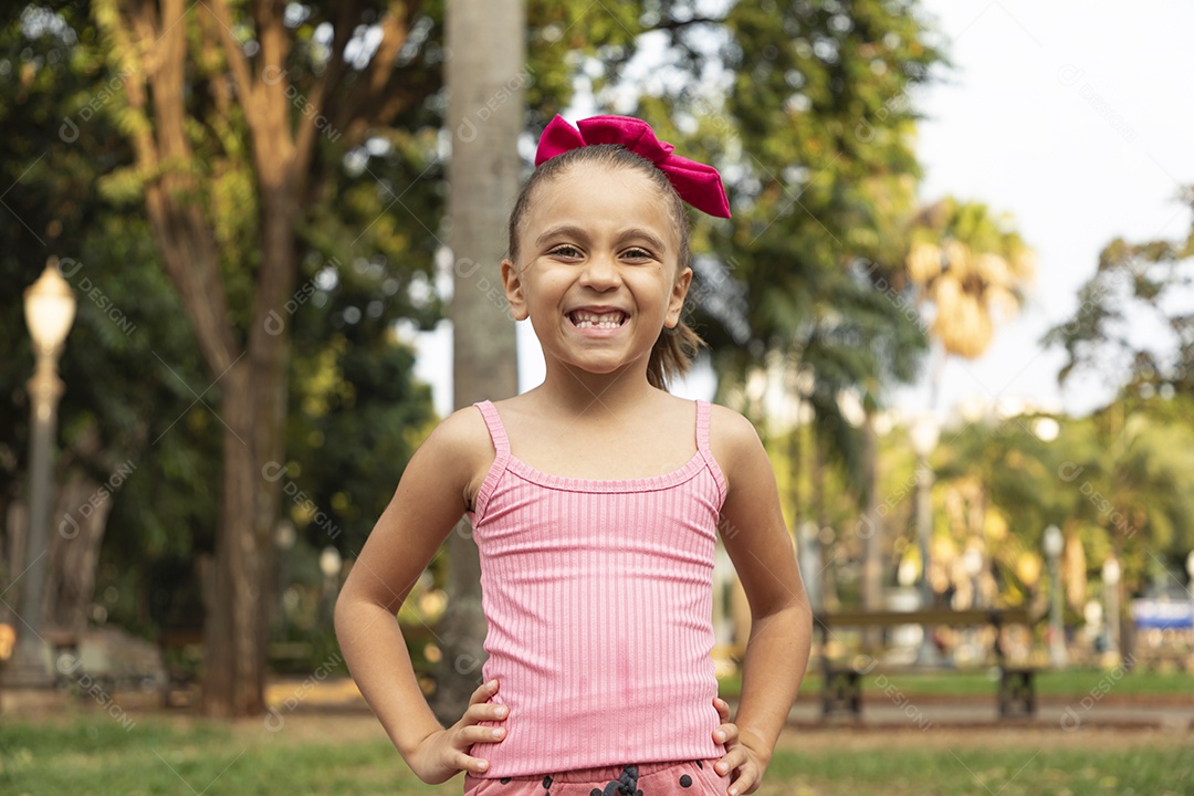 Menina linda sorrindo de mãos na cintura