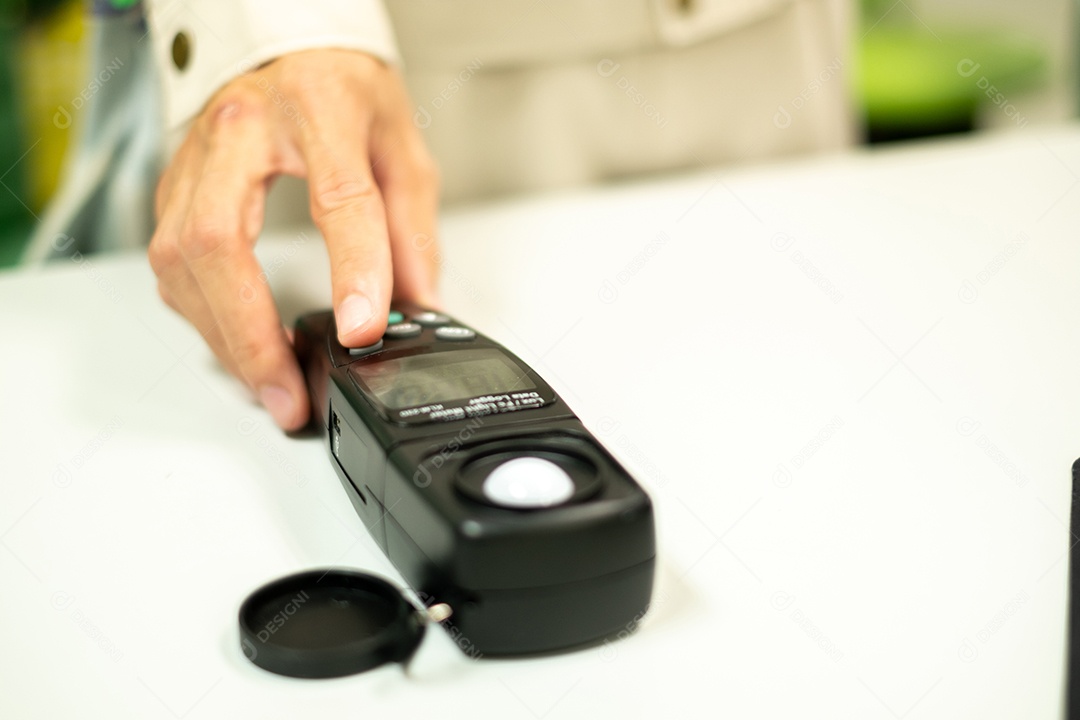 A mão de um eletricista está segurando um medidor de luz