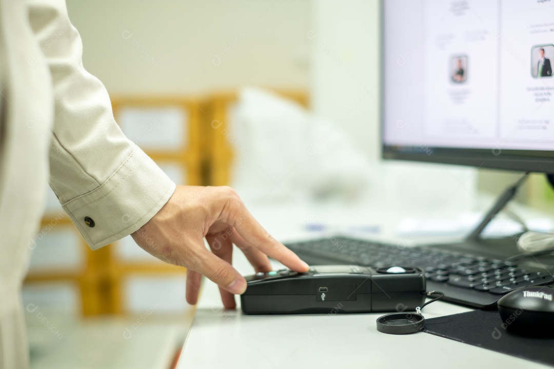 A mão de um eletricista está segurando um medidor de luz no local de trabalho
