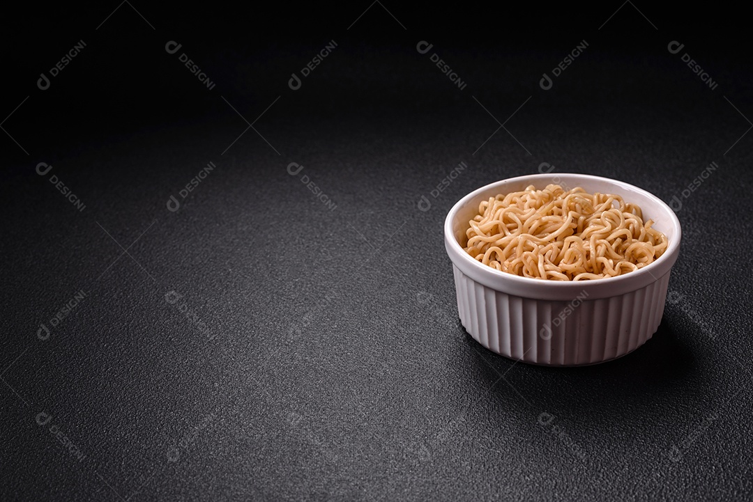 Macarrão de arroz de prato asiático com sal e especiarias em fundo escuro de concreto