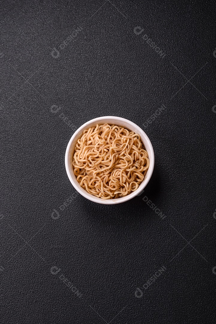 Macarrão de arroz de prato asiático com sal e especiarias em fundo escuro de concreto