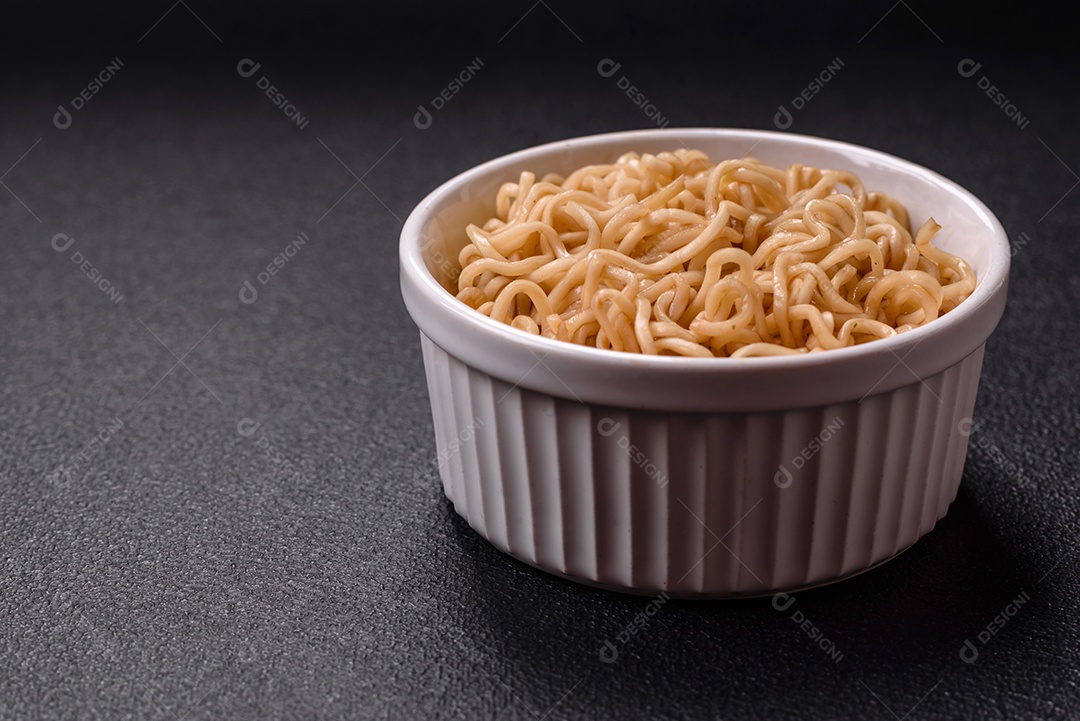 Macarrão de arroz de prato asiático com sal e especiarias em fundo escuro de concreto