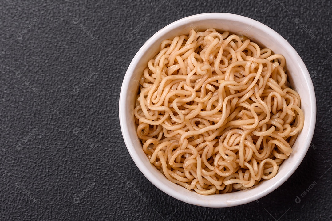 Macarrão de arroz de prato asiático com sal e especiarias em fundo escuro de concreto