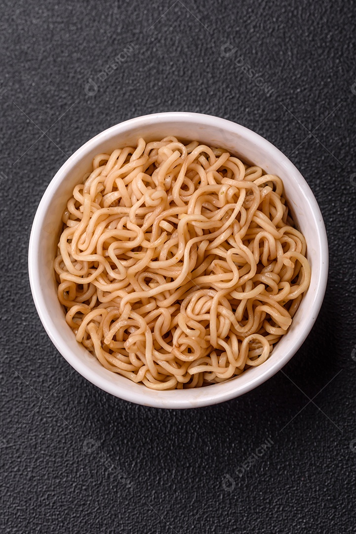 Macarrão de arroz de prato asiático com sal e especiarias em fundo escuro de concreto