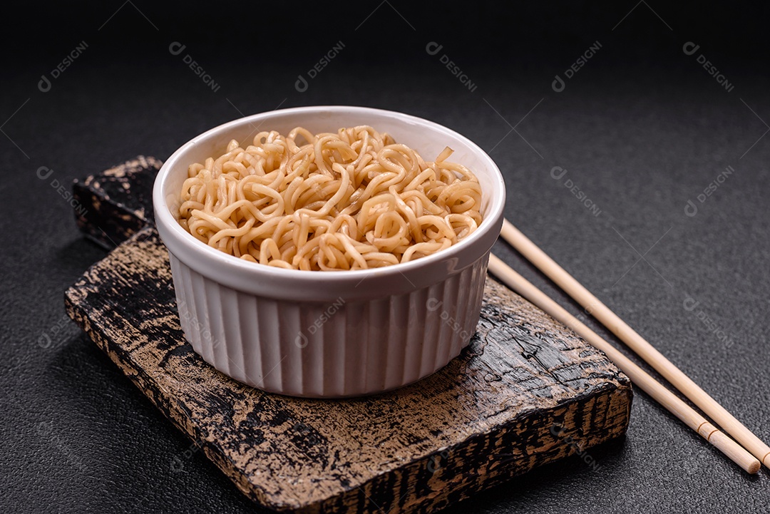 Macarrão de arroz de prato asiático com sal e especiarias em fundo escuro de concreto