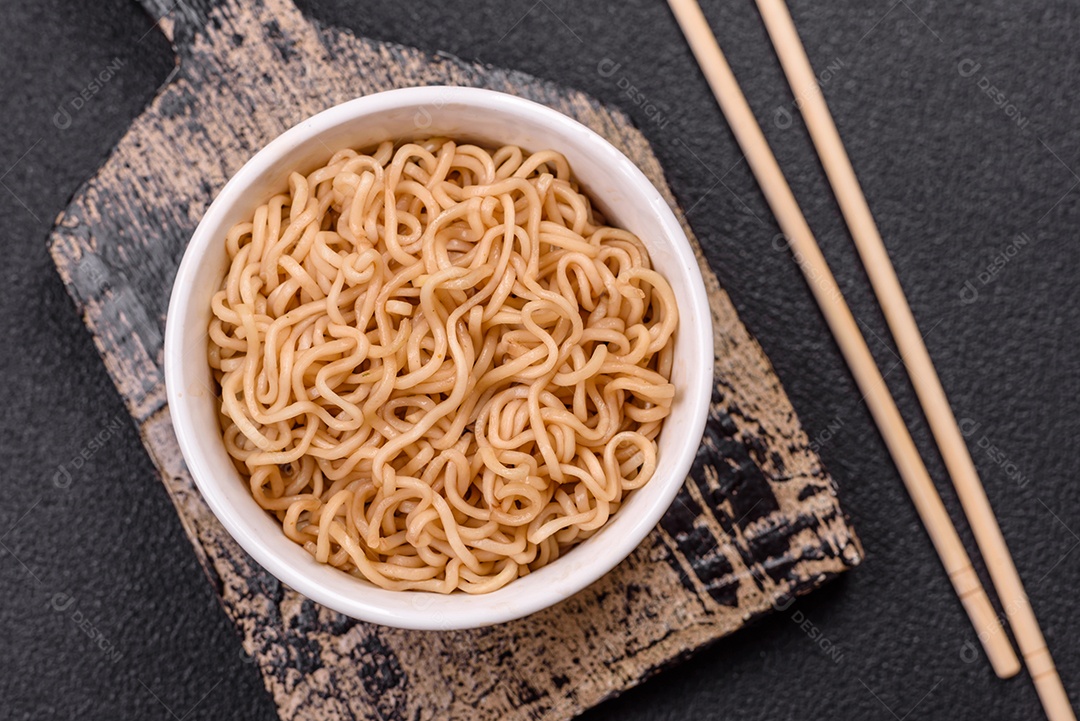 Macarrão de arroz de prato asiático com sal e especiarias em fundo escuro de concreto