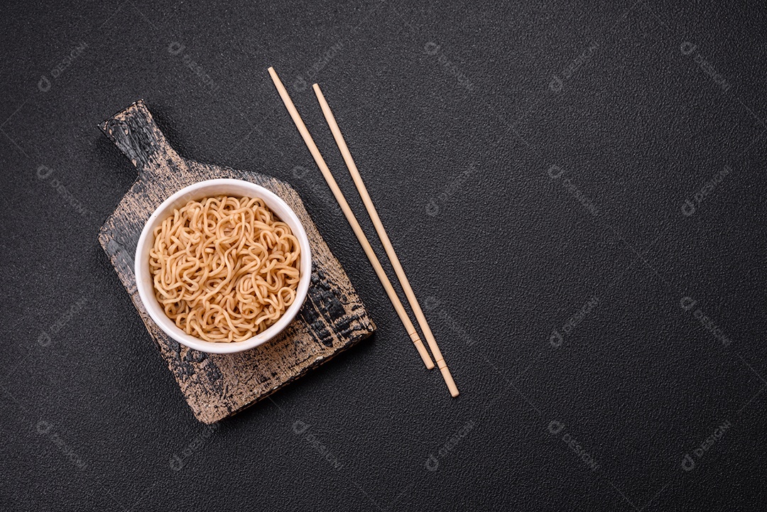 Macarrão de arroz de prato asiático com sal e especiarias em fundo escuro de concreto