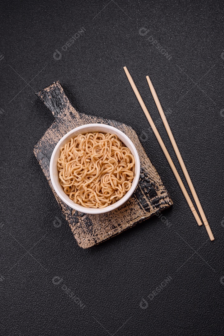 Macarrão de arroz de prato asiático com sal e especiarias em fundo escuro de concreto