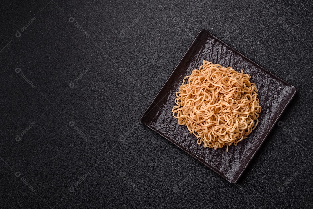 Macarrão de arroz de prato asiático com sal e especiarias em fundo escuro de concreto