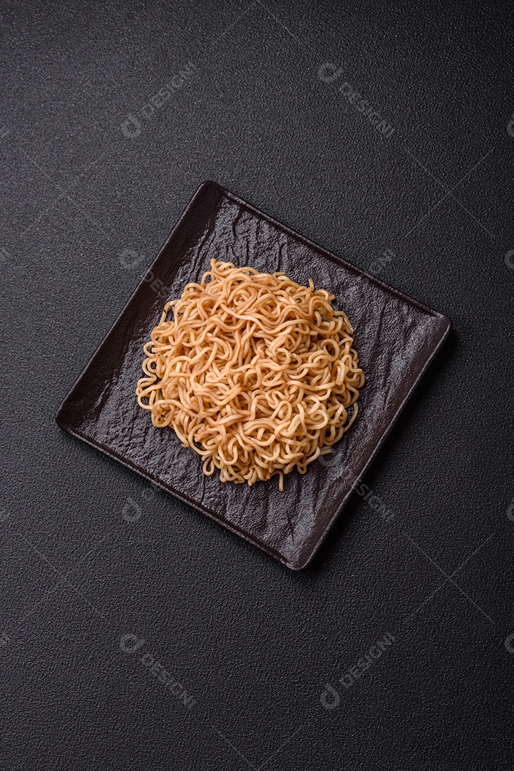 Macarrão de arroz de prato asiático com sal e especiarias em fundo escuro de concreto