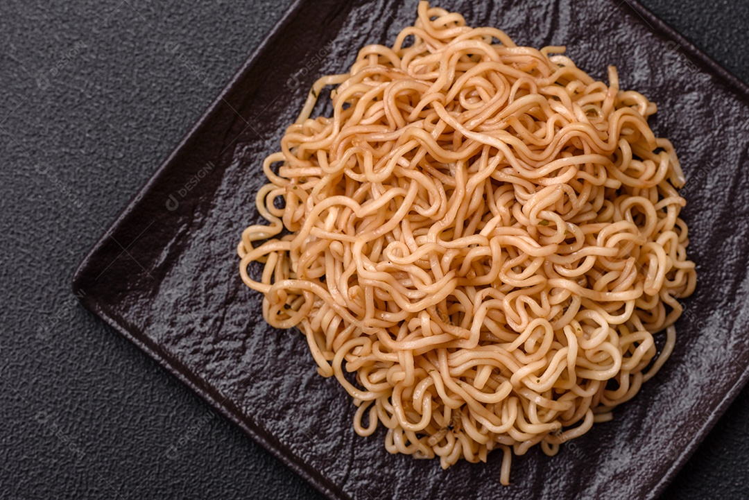 Macarrão de arroz de prato asiático com sal e especiarias em fundo escuro de concreto