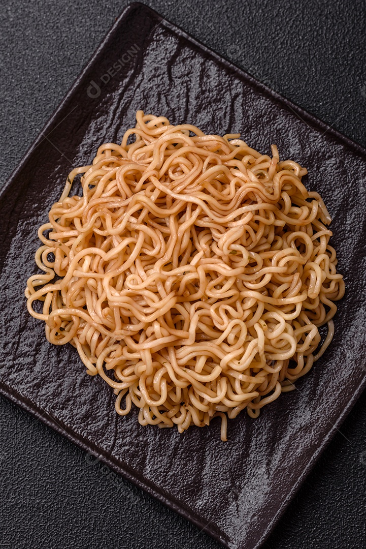 Macarrão de arroz de prato asiático com sal e especiarias em fundo escuro de concreto