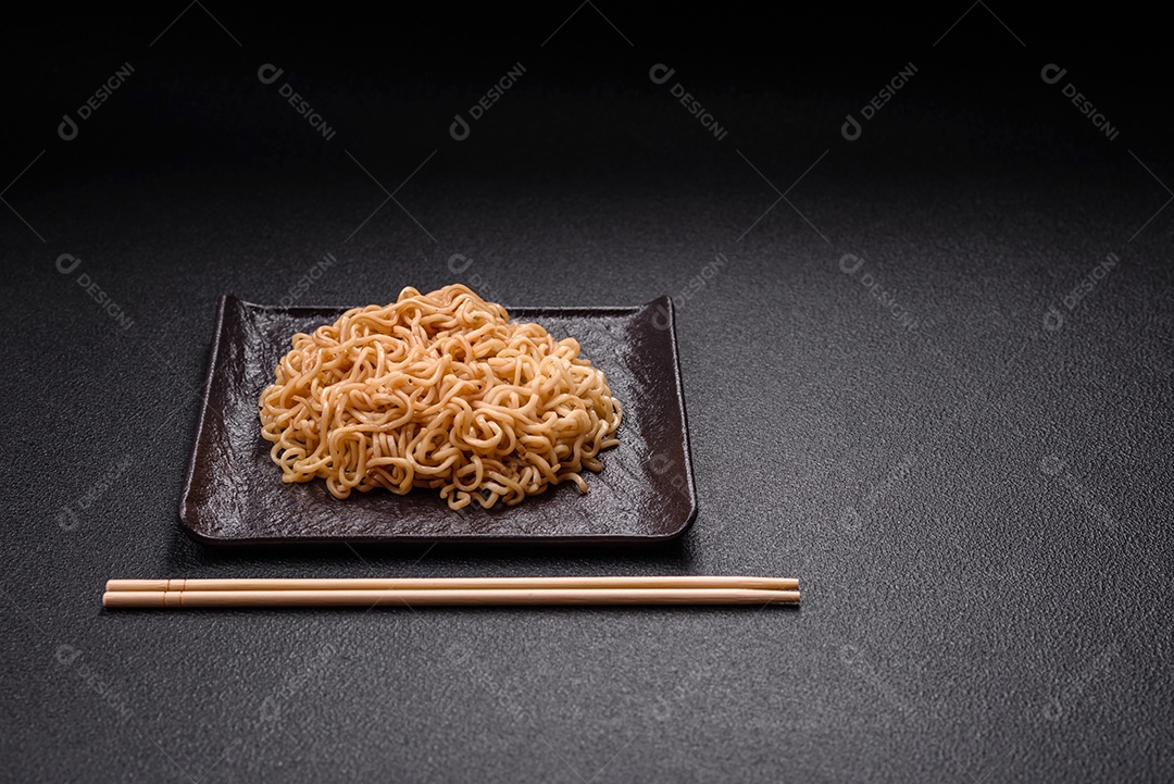 Macarrão de arroz de prato asiático com sal e especiarias em fundo escuro de concreto