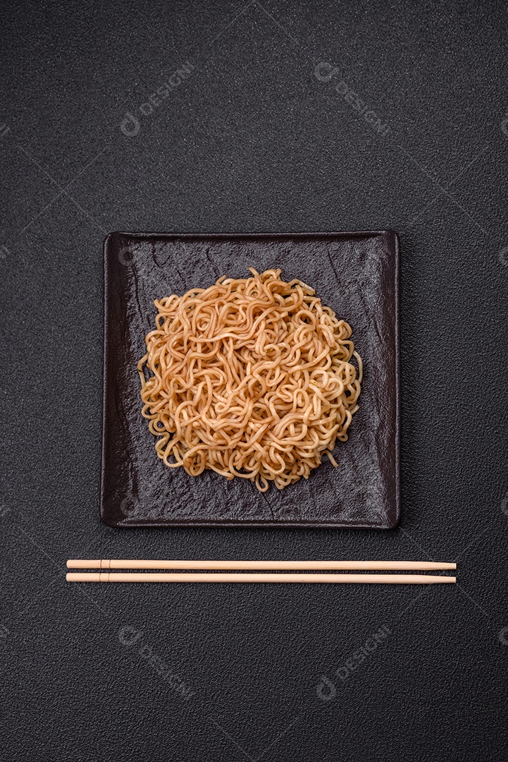 Macarrão de arroz de prato asiático com sal e especiarias em fundo escuro de concreto