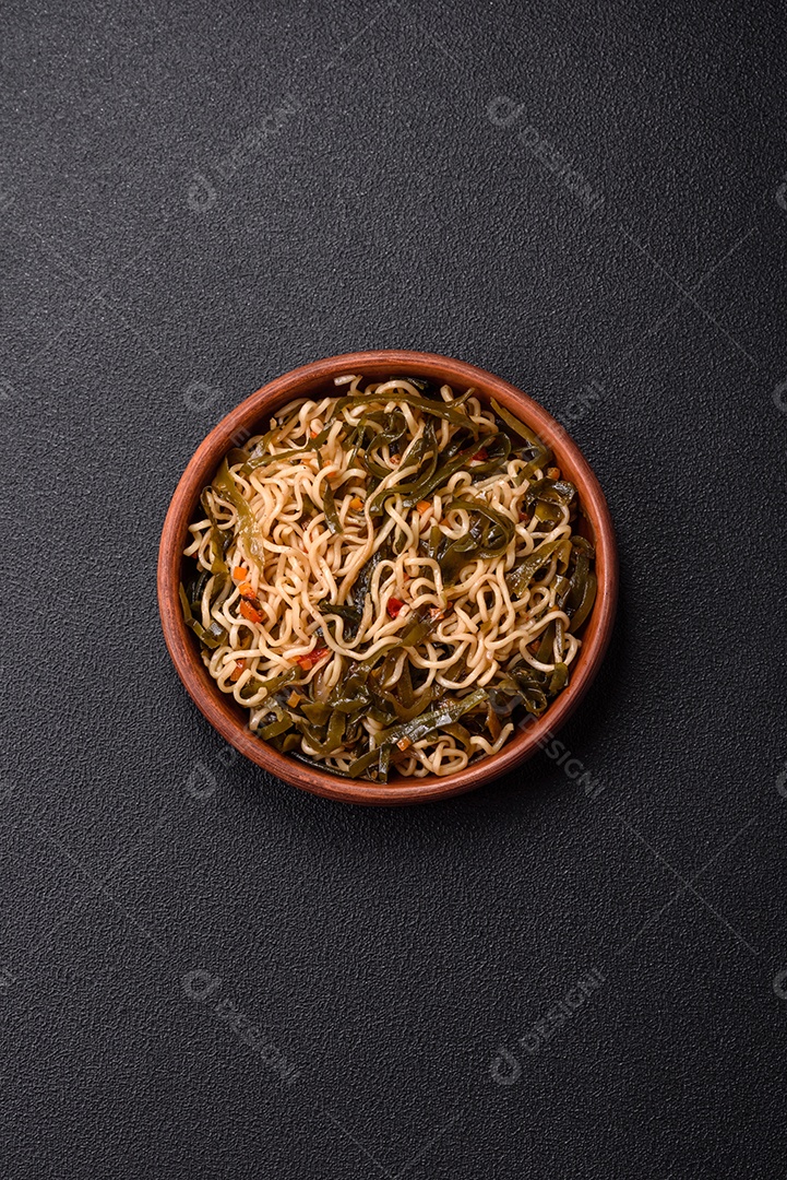 Macarrão de arroz de prato asiático com sal e especiarias em fundo escuro de concreto