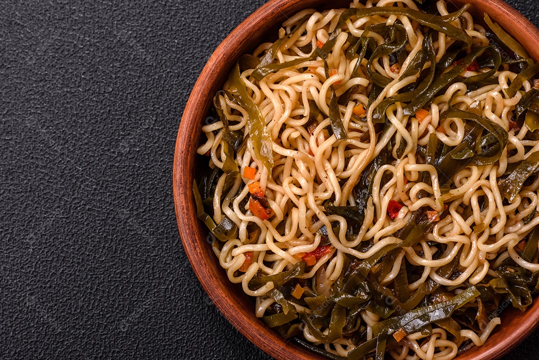 Macarrão de arroz de prato asiático com sal e especiarias em fundo escuro de concreto