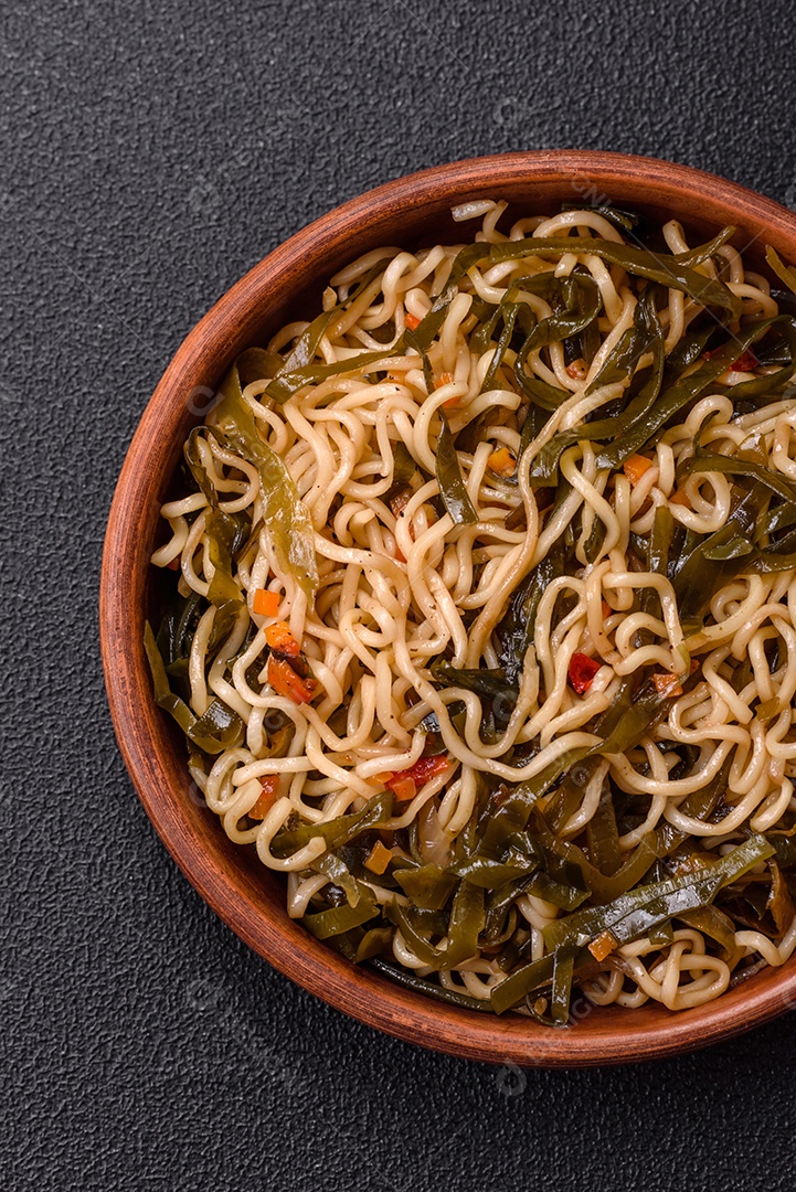 Macarrão de arroz de prato asiático com sal e especiarias em fundo escuro de concreto