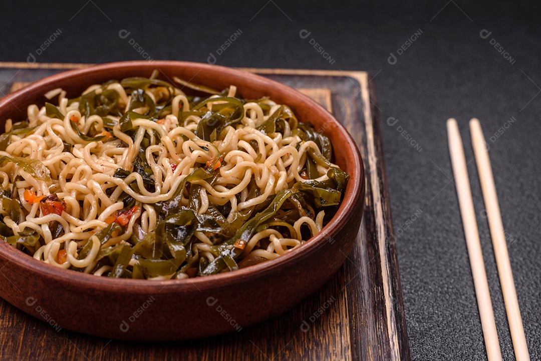 Macarrão de arroz de prato asiático com sal e especiarias em fundo escuro de concreto