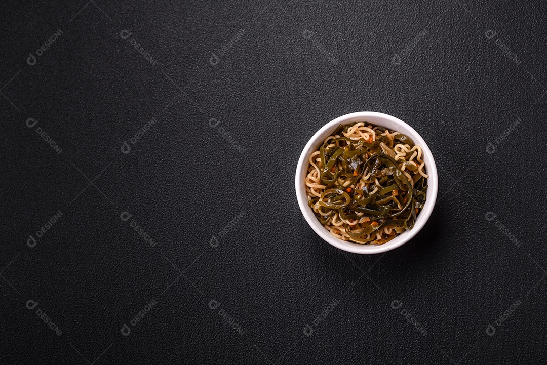 Macarrão de arroz de prato asiático com sal e especiarias em fundo escuro de concreto