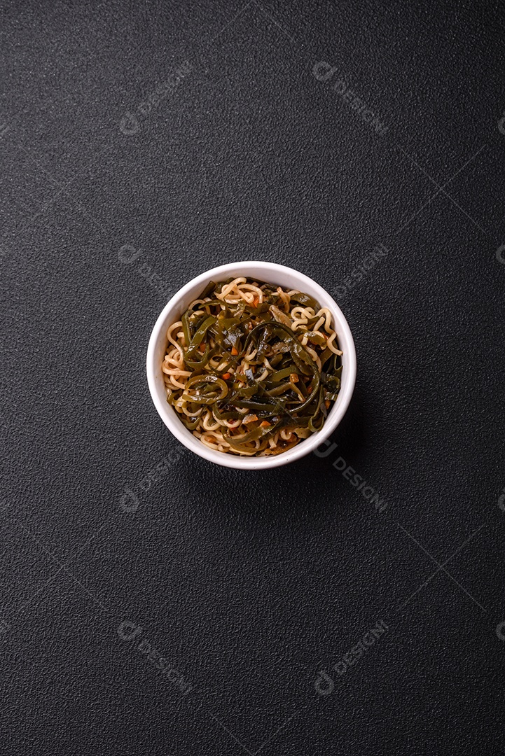 Macarrão de arroz de prato asiático com sal e especiarias em fundo escuro de concreto