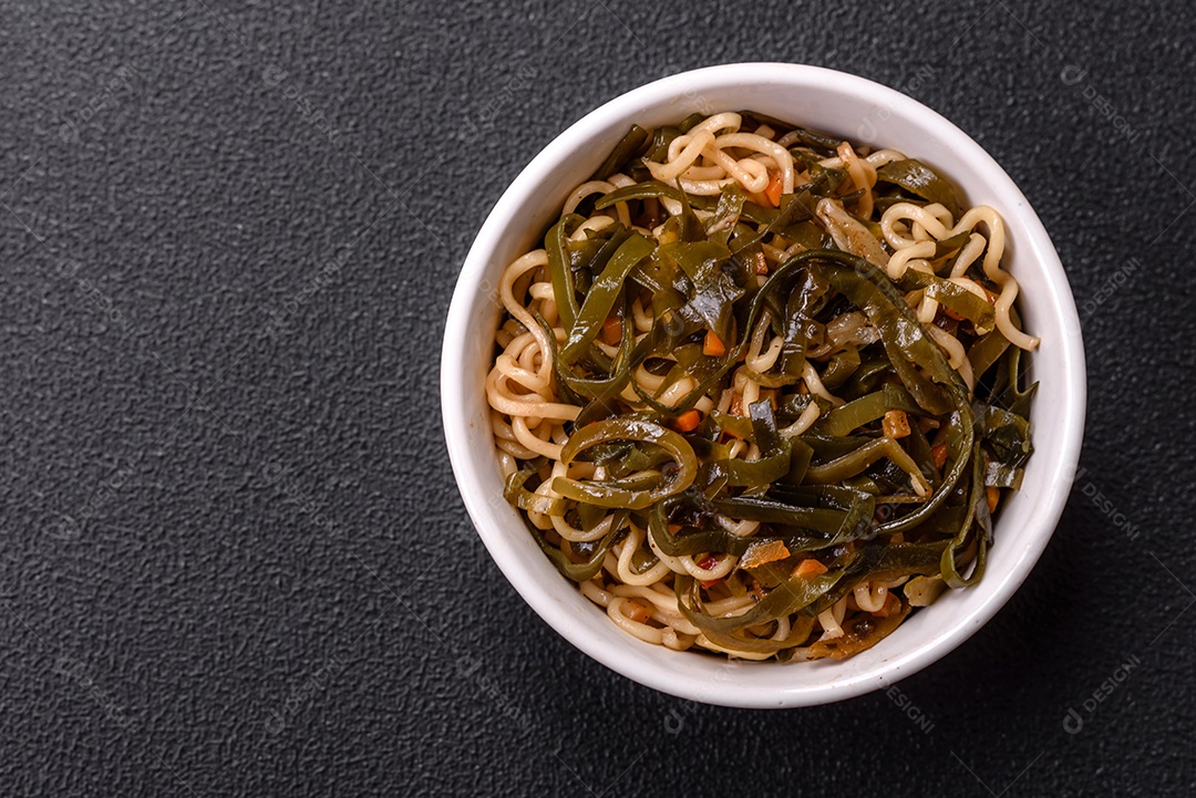Macarrão de arroz de prato asiático com sal e especiarias em fundo escuro de concreto