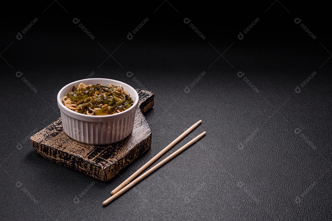 Macarrão de arroz de prato asiático com sal e especiarias em fundo escuro de concreto