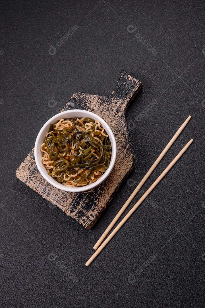 Macarrão de arroz de prato asiático com sal e especiarias em fundo escuro de concreto