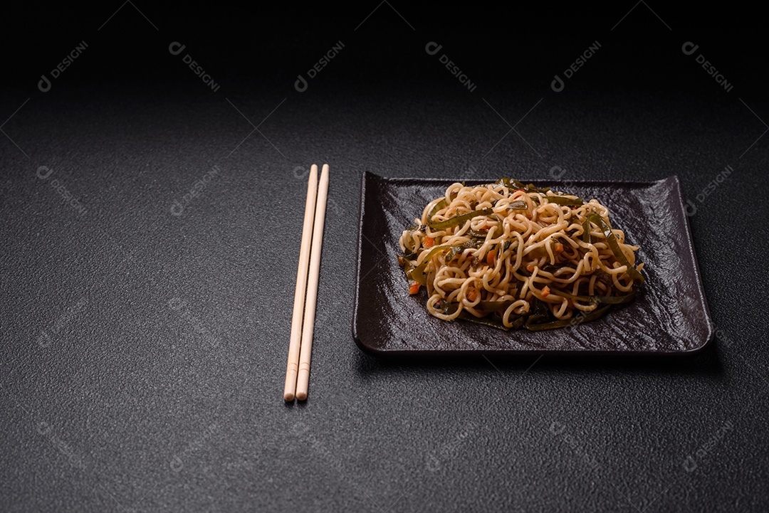 Macarrão de arroz de prato asiático com sal e especiarias em fundo escuro de concreto