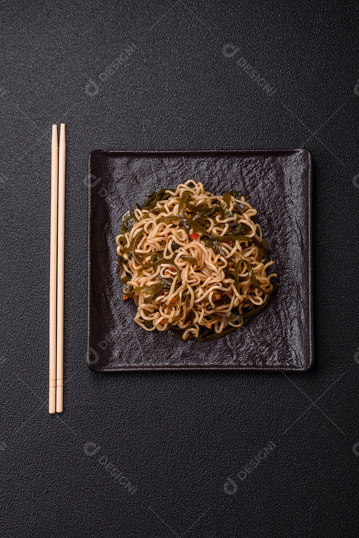 Macarrão de arroz de prato asiático com sal e especiarias em fundo escuro de concreto
