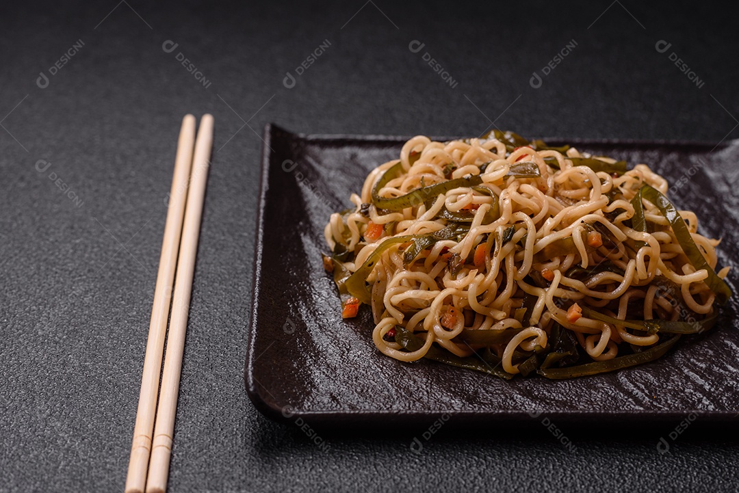 Macarrão de arroz de prato asiático com sal e especiarias em fundo escuro de concreto