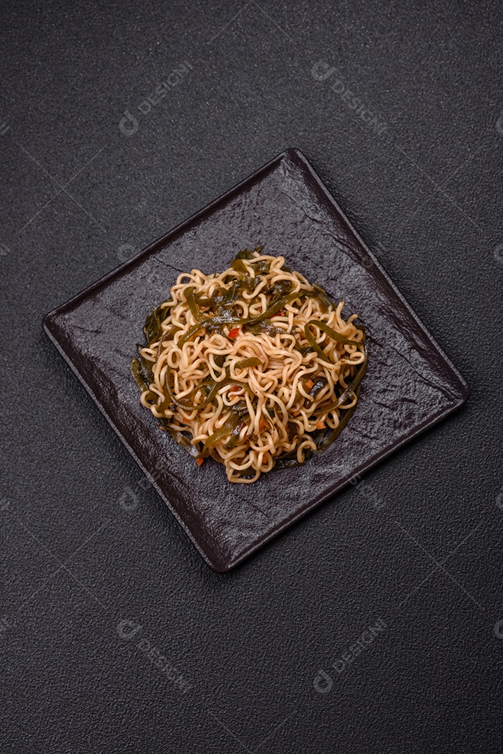 Macarrão de arroz de prato asiático com sal e especiarias em fundo escuro de concreto