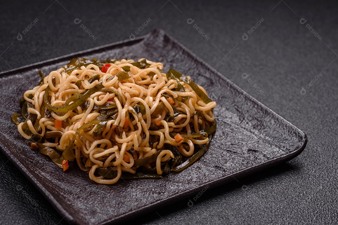 Macarrão de arroz de prato asiático com sal e especiarias em fundo escuro de concreto