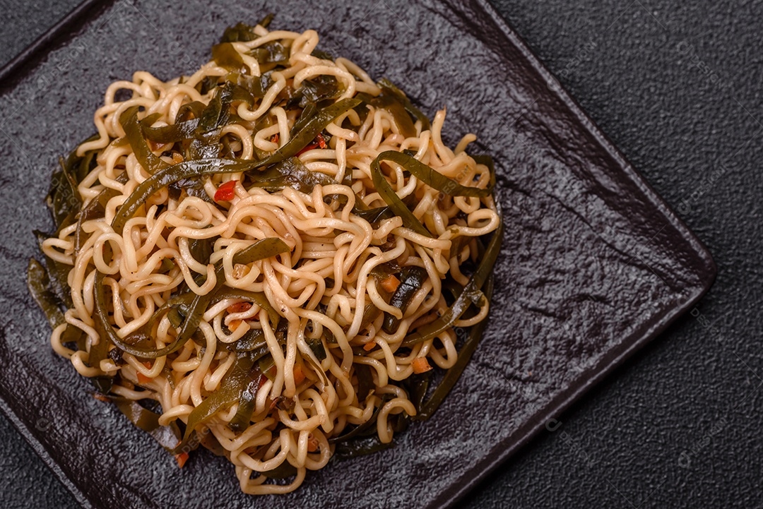 Macarrão de arroz de prato asiático com sal e especiarias em fundo escuro de concreto