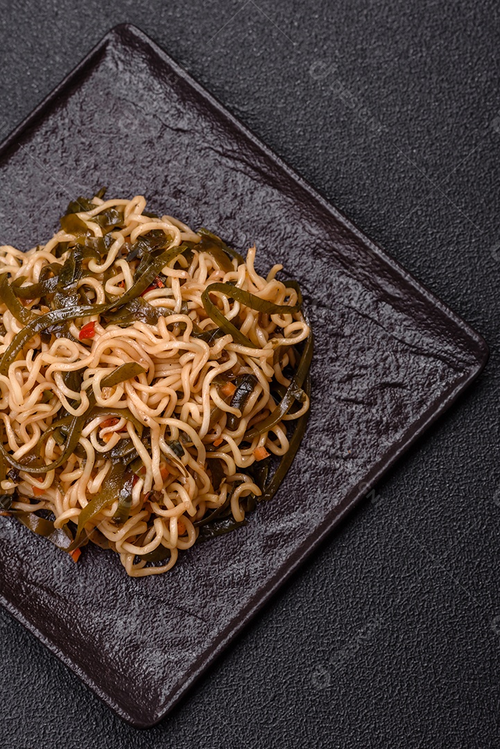 Macarrão de arroz de prato asiático com sal e especiarias em fundo escuro de concreto