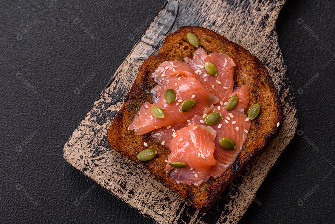 Torradas grelhadas com pasta de abacate, ovos, cream cheese, sal, especiarias e ervas sobre uma mesa de concreto texturizado