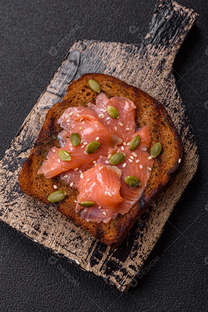 Torradas grelhadas com pasta de abacate, ovos, cream cheese, sal, especiarias e ervas sobre uma mesa de concreto texturizado
