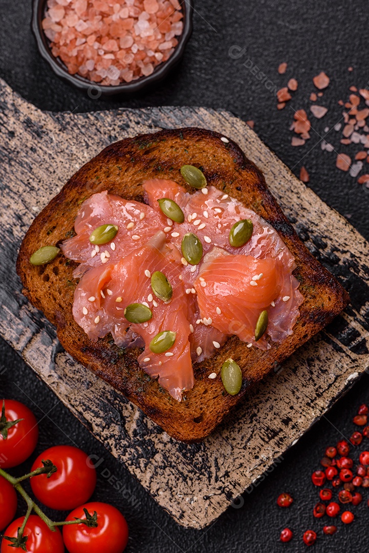 Torradas grelhadas com pasta de abacate, ovos, cream cheese, sal, especiarias e ervas sobre uma mesa de concreto texturizado